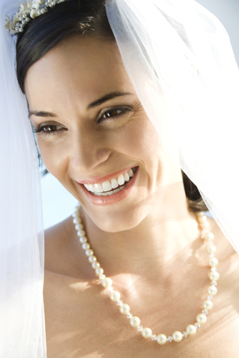 Verschiedene romantische Brautaccessoires - Lächelnde Braut mit Perlenkette