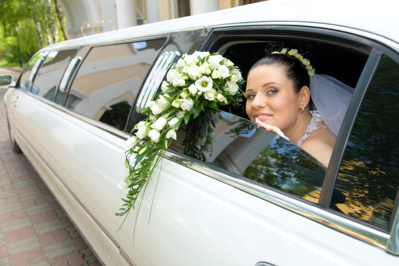 Hochzeitsfahrzeuge und Kutschen - Die Braut schaut aus der Limousine